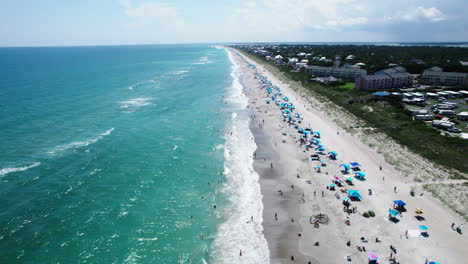 Beautiful-aerial-footage-at-the-beach-with-turquoise-ocean-waters-and-people-on-the-shore