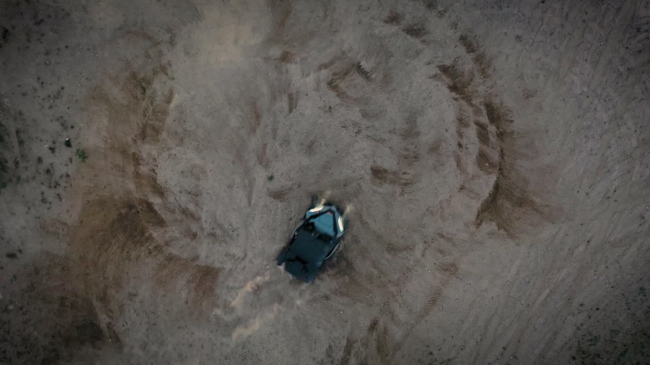 Quad ATV che fa i "donuts", ripreso con drone dall'alto.