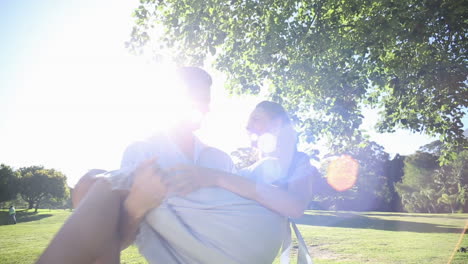 man picking up his pretty girlfriend in the park