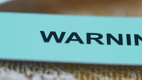 close-up of a light teal warning label.