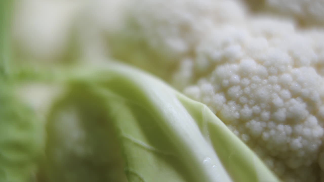 Macro slider shot of fresh cauliflower head and leaves healthy organic vegetable
