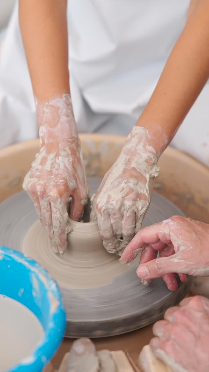 manos moldeando arcilla en una rueda de cerámica
