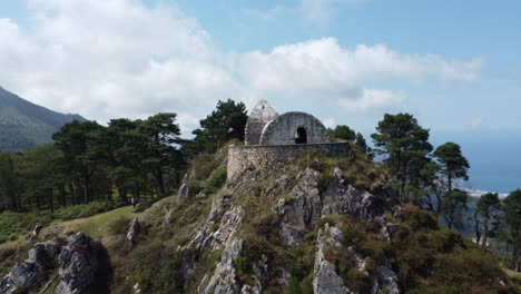 从山中间的石头房子中缩放出来,背景是海