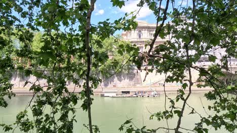 scenic river framed by lush green leaves and architecture