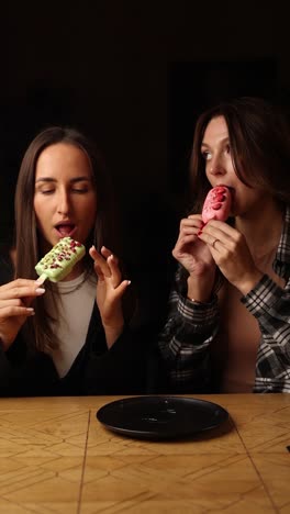 dos mujeres compartiendo helados de postre