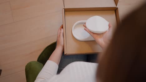 woman unboxing a white ceramic dish holder