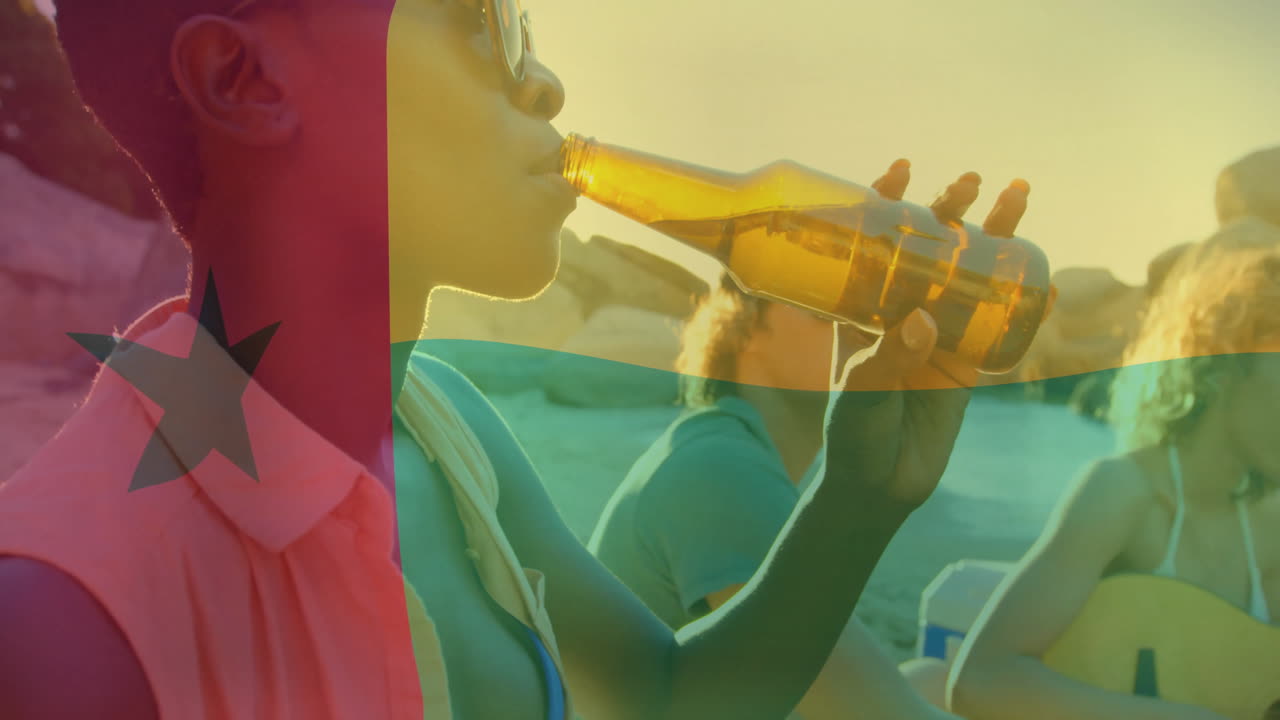 At beach gathering, person drinking from bottle with animation of flag overlay