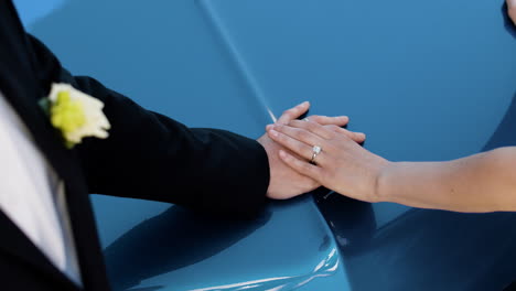 couples hands on blue car