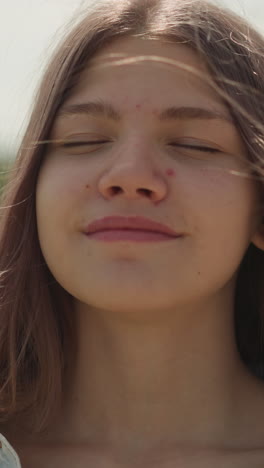 pensive teen female with long loose hair fantasizes closing eyes. pretty teenage girl smiles contentedly imagining pleasant events closeup on blurred background