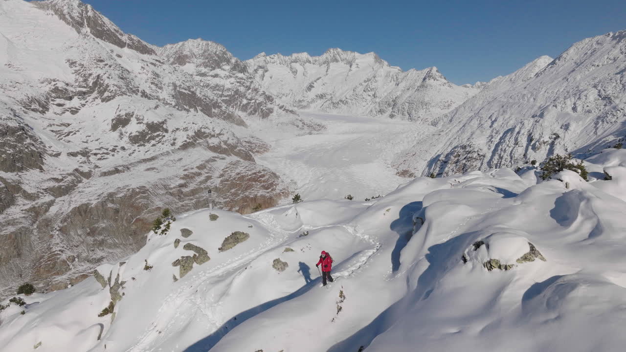 뒤에 빙하와 함께 화창한 날에 눈 신발을 신고 걷는 사람과 스위스에서 공중 촬영