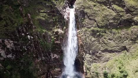 single drop waterfall flowing down the rocky cliff in summer