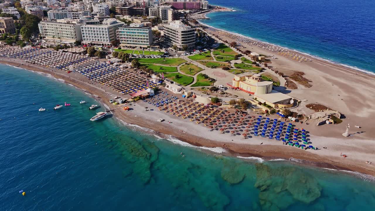Şemsiyeler ve binaların bulunduğu bir plajın havadan görünümü