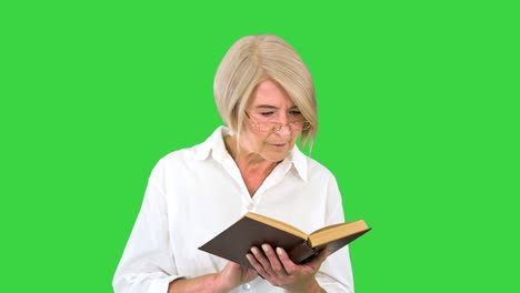 senior lady woman reading old book with glasses on a green screen, chroma key