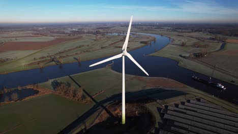 Single-windmill-and-solar-panel-park-in-The-Netherlands-part-of-sustainable-industry-where-Dutch-river-IJssel-and-Twentekanaal-meet