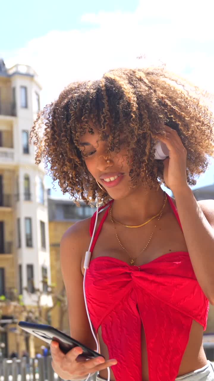 Woman with Curly Hair Listening to Music Outdoors