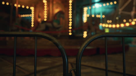 a close-up of a gate with a carousel in the background