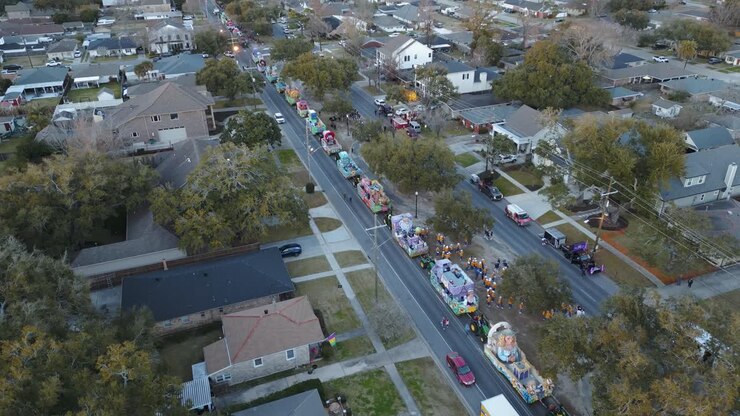 Una vivace strada suburbana si trasforma in uno spettacolo vibrante mentre una parata aerea cattura l'essenza della comunità, mostrando il diverso design urbano e la vivace area residenziale.