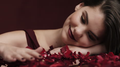 portrait beautiful caucasian woman playing with rose petals falling sensual female dreaming of intimate fantasy romance indulging desire in red background valentines day concept