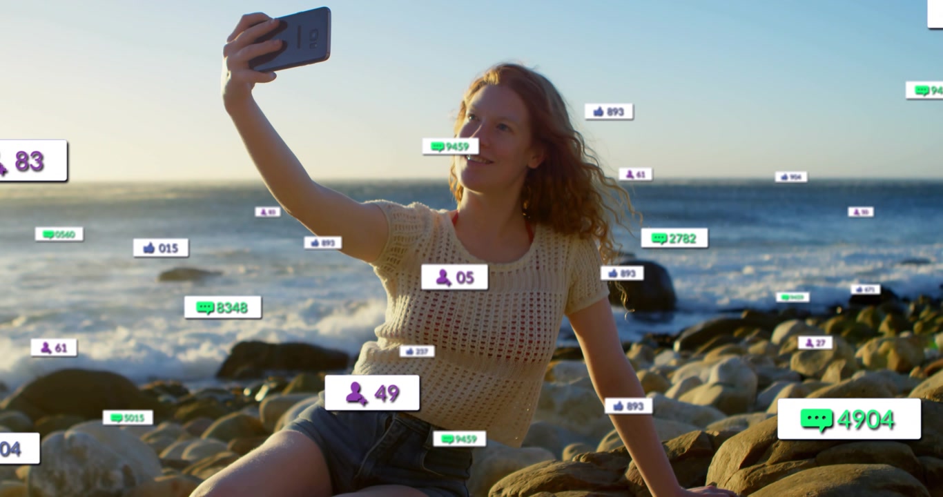 Vertical video: Woman raising phone on rock for likes, driving social media counts up around her