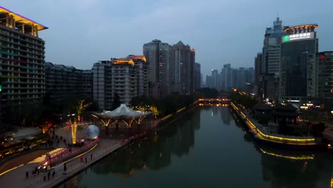 city lights at night in downtown chengdu, china - establishing aerial drone