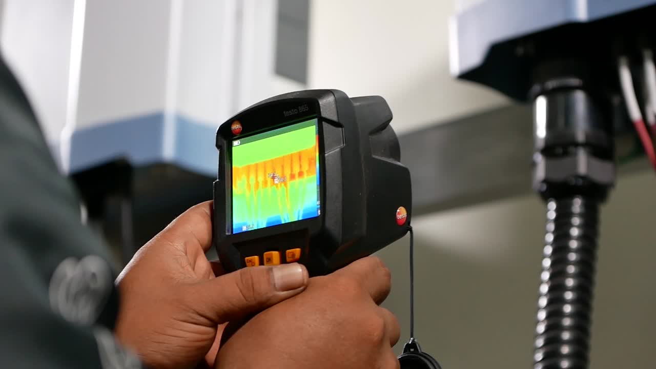 técnico asiático usa un dispositivo térmico para verificar la temperatura del cable eléctrico-4