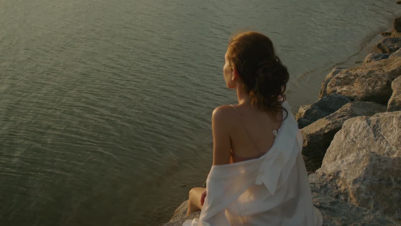 Woman Contemplating Sunset Over Water