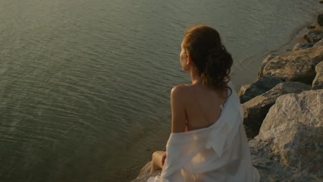 woman contemplating sunset over water