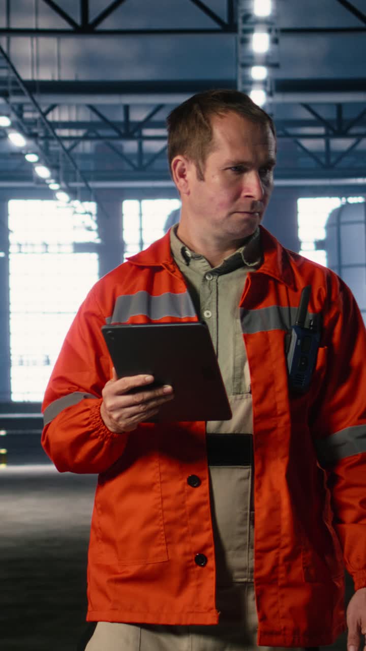 Vertical Video Inspector oversees machinery operation in a warehouse using tablet