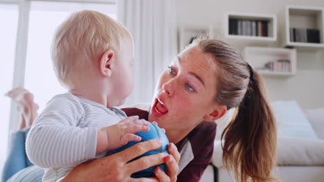 Young-mum-playing-with-toddler-son-and-ball,-close-up