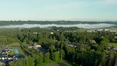 Drohnen-Dolly-Aufnahme-Einer-Kleinen-Landstadt-Mit-Nebel-Im-Wald