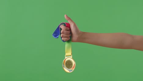 golden medal in hand. green screen background