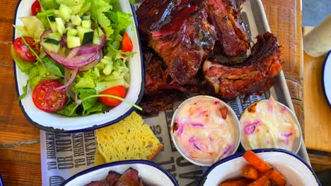 pechuga de ternera con ensalada, costillas de cerdo con batatas fritas, pan de maíz y ensalada de col, comida americana tradicional, vista superior de 4k