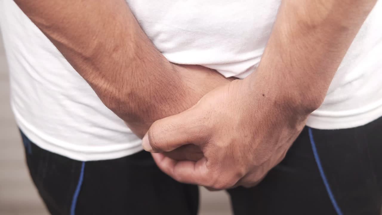 hombre sosteniendo su ingle