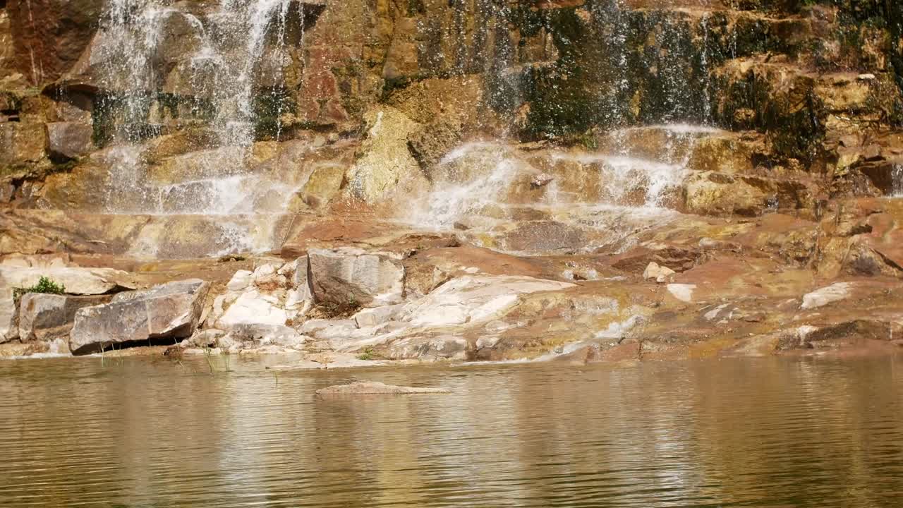 숲 속의 절벽에서 아름다운 폭포: 숲 속에 있는 돌들 사이에서 흐르는 하천, 흐르는 물의 4k 비디오