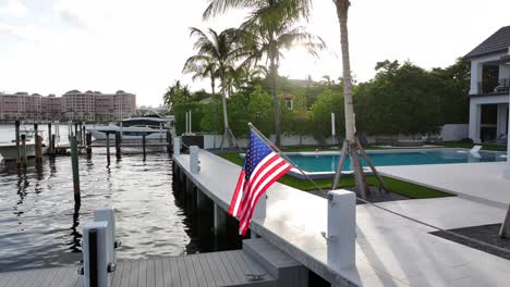 bandera estadounidense en el muelle de la mansión privada con palmeras