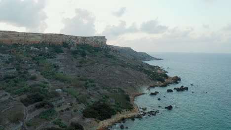 Coastline-of-Malta-Island-at-Sunset-with-Cliff-and-Ocean-Waves,-Aerial-Drone-Perspective-forward-dolly