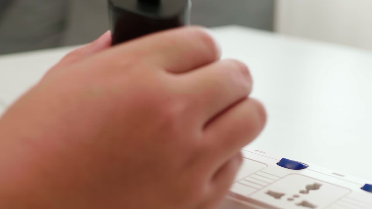 cierre la mano del hombre desconectando la batería del adaptador del teléfono y apague el interruptor quitando el cargador