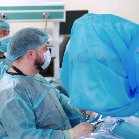 doctors conduct a surgery. medical workers in blue protective uniform work in the operating room in clinic. surgical procedure in operating theater.