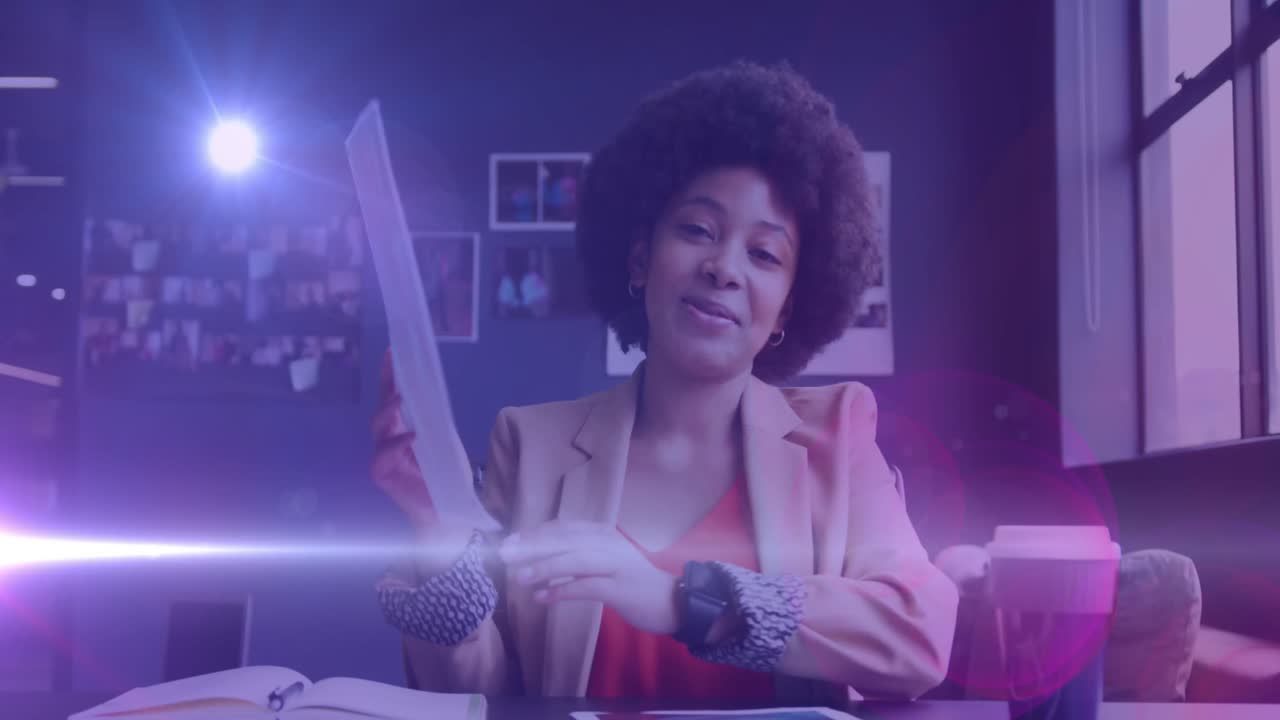Animation of light spots over african american businesswoman having video call and smiling
