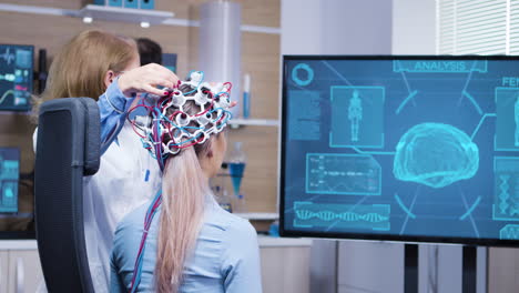 paciente femenina mirando su actividad cerebral en la pantalla de la tv