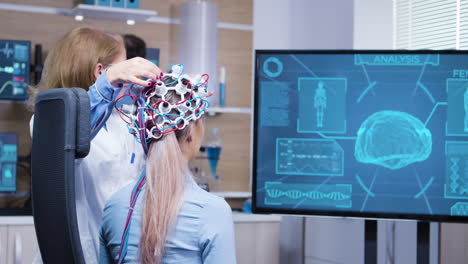 female patient looking at her brain activity on tv screen