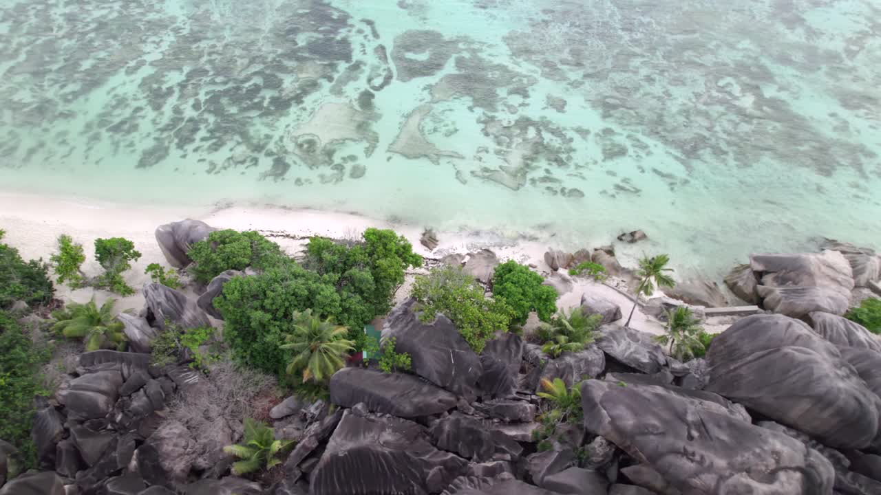 Ripresa drone di una spettacolare spiaggia con bassa marea e rocce di granito di Anse Source d'Argent, La Digue, Seychelles 019 30fps