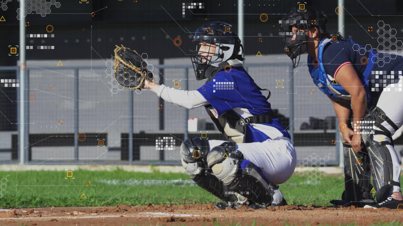 Female catcher and umpire crouching behind home plate on baseball field with mitt mask and fence