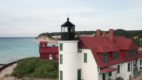 historic point betsie lighthouse in frankfort, michigan located along lake michigan with drone video close up on the side moving in