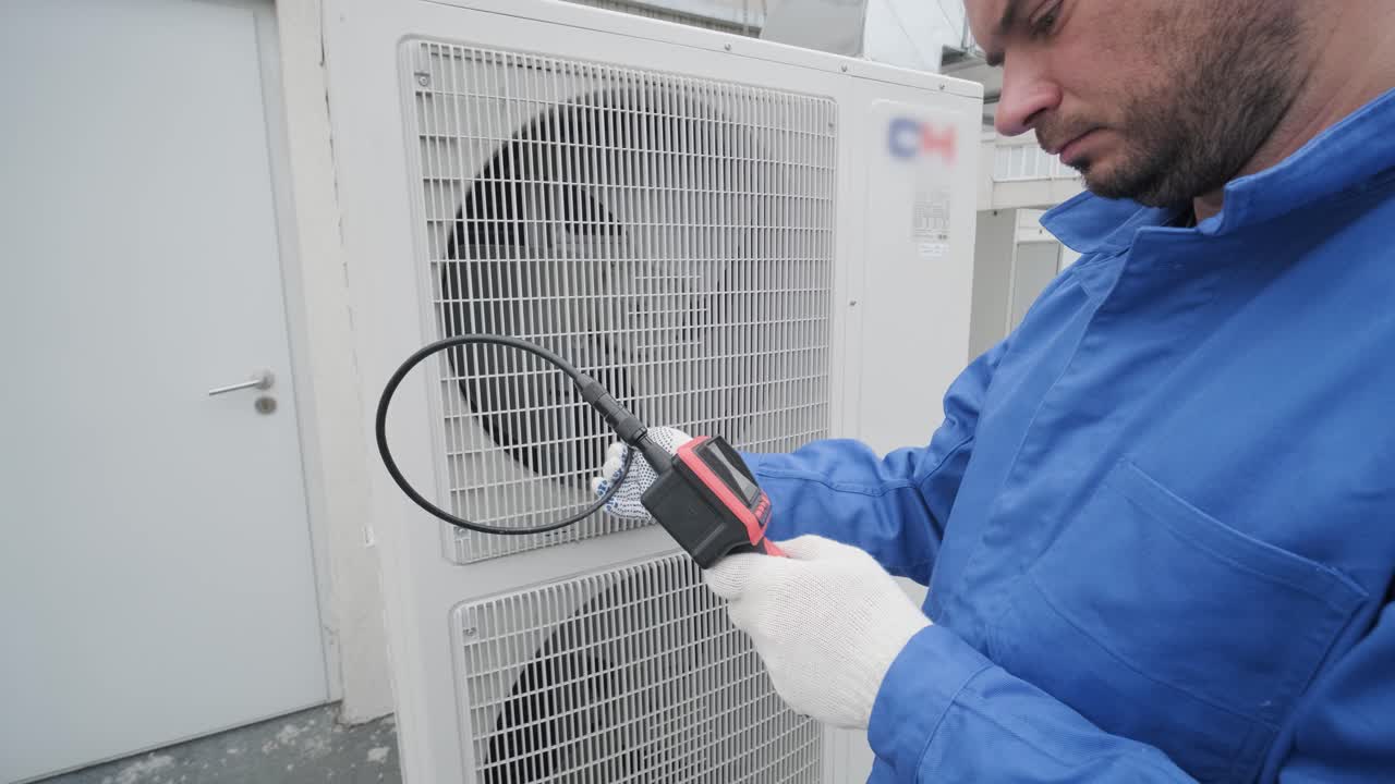 The technician uses a digital camera to check the clogging of the heat exchanger
