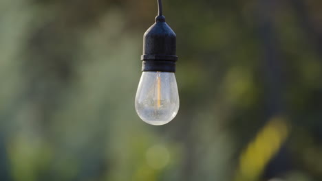 una sola bombilla colgante de guirnaldas de luces decorativas para exteriores está apagada