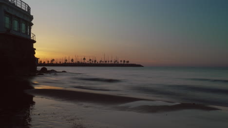 Das-Zeitraffervideo-Fängt-Den-Sonnenaufgang-Ein,-Wobei-Sich-Die-Goldene-Skyline-Entlang-Der-Küste-Wunderschön-Im-Meer-Spiegelt