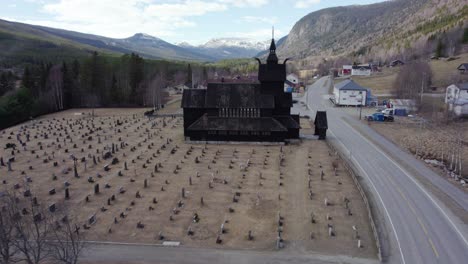 aerial view approaching a stave church replica, spring day in uvdal, norway