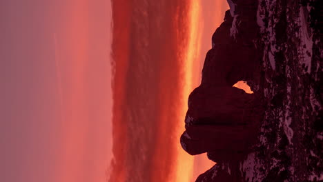 Vertical-4k-Timelapse,-Dawn-in-Arches-National-Park,-Utah-USA,-Red-Orange-Sky-and-Clouds-Above-Rock-Formations