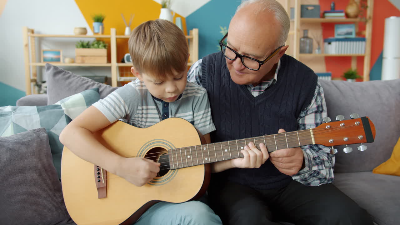 Nonno che insegna al nipote a suonare la chitarra